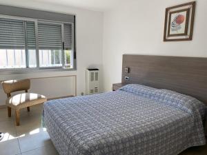 1 dormitorio con 1 cama, 1 silla y 2 ventanas en Meerblick San Bernardo en San Bernardo
