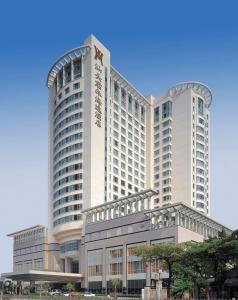 汕頭的住宿－汕頭君華海逸酒店，一座白色的大建筑,有很多窗户