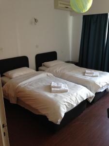 two beds in a room with towels on them at Francis Apartments in Larnaca