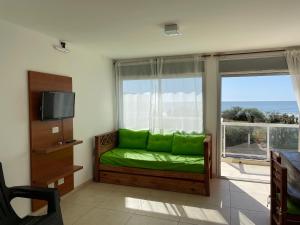 a living room with a green couch in front of a window at Meerblick San Bernardo in San Bernardo