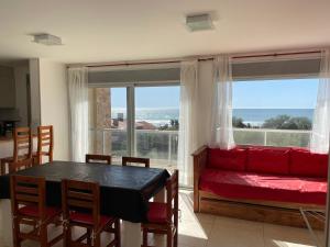a living room with a red couch and a table at Meerblick San Bernardo in San Bernardo