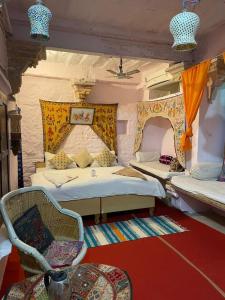 a room with two beds and a chair in it at Shiva Guest House in Jaisalmer