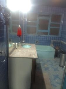 a blue tiled bathroom with a sink and a tub at Recamara en Polanco (solo hombres) in Mexico City