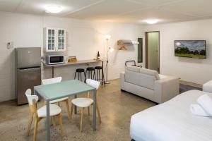 een keuken en woonkamer met een tafel en een bank bij Bridgewater Motel Victoria-24 HourCheck-In in Bridgewater-on-Loddon