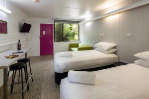 a hotel room with two beds and a red door at 24HourCheck-In- Bridgewater Motel-Victoria-Australia in Bridgewater-on-Loddon