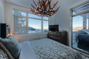 a bedroom with a bed and a large window at Fully Renovated Ski-in/out Loft with Private Hot Tub! in Golden
