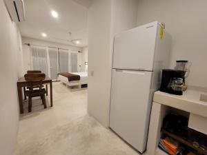 a kitchen with a white refrigerator in a room at Alojamiento Brisas Inter Starlink in Brisas de Zicatela