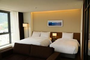 Postel nebo postele na pokoji v ubytování Ramada Encore by Wyndham Busan Haeundae