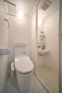 a white bathroom with a toilet and a sink at Ano Hotel Asakusa in Tokyo