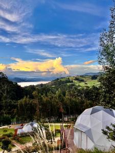 a couple of domes in a field with a view at Golden Glamping in Guatavita