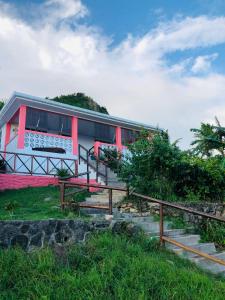 una pequeña casa con un rojo y blanco en Posada Halley View en Providencia