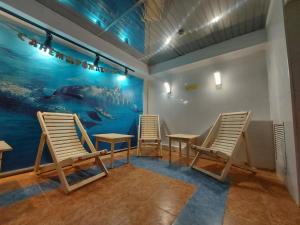 una habitación con 3 sillas y una pared con un acuario en Astra, en Chelyabinsk