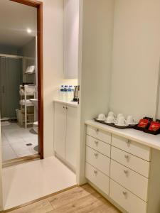 a kitchen with white cabinets and a mirror at Tainan Anping - Shuiau 180 in Anping