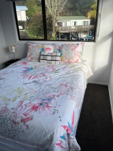 a bedroom with a bed with a large window at Cozy 2 bedroom with room for a boat in Paihia