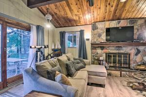 sala de estar con sofá y chimenea de piedra en Lakefront Forestville Paradise with Private Beach!, en Forestville
