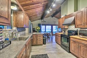 a large kitchen with wooden cabinets and a dining room at Lakefront Forestville Paradise with Private Beach! 