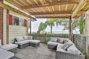 a patio with couches and a wooden pergola at Lakefront Forestville Paradise with Private Beach! 