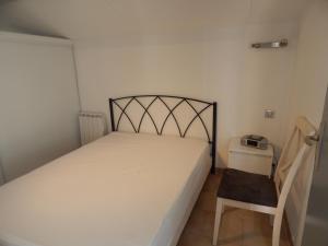 a small bedroom with a bed and a chair at IBIS in Saint Pierre La Mer