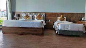 a hotel room with two beds and a chair at Ivory Phu Yen Hotel in Tuy Hoa