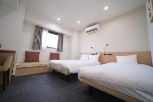 Ano Hotel Asakusa في طوكيو: غرفة فندقية بسريرين ونافذة