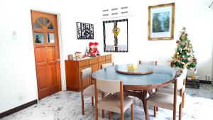 a dining room with a table and a christmas tree at Advent Villa, Penang - Near Adventist Hospital in George Town