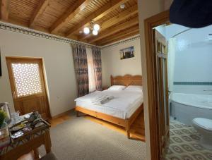 a bedroom with a bed and a bathroom with a tub at Old Bukhara Boutique in Bukhara