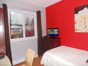 a red bedroom with a bed and a window at Gordon's Guest House in Vancouver