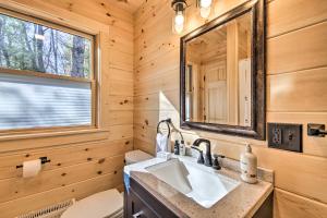 a bathroom in a log cabin with a sink and a mirror at Inviting Webb Lake Cabin with Mountain Views in Weld