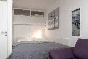 1 dormitorio con 1 cama y 1 sofá en Am Hang 15 Seeblick App 7 en Scharbeutz