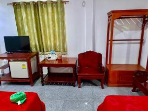 Habitación con escritorio y mesa con ordenador portátil. en โรงเกลือรีสอร์ท, en Aranyaprathet