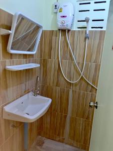 een badkamer met een wastafel en een spiegel aan de muur bij โรงเกลือรีสอร์ท in Aranyaprathet