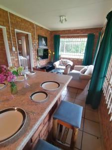 a bathroom with three sinks and a living room at Stone Circle Cottage in Lydenburg