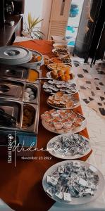 Hotel Zaitona في أربيل: طاولة طويلة عليها أطباق من الطعام