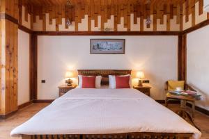 una camera da letto con un letto grande con cuscini rossi di Cottage On The Lake by VEO - Part of StayVista a Bhimtal