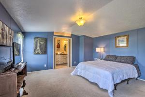 Dormitorio azul con cama y TV en Peaceful MI Home on 1 Acre Pets Welcome!, 