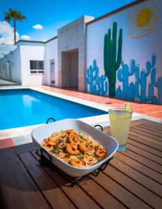 a dish of food sitting on a table next to a pool at Hotel Buen Valle in Torreón