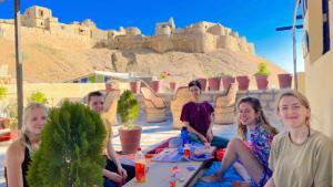 un grupo de personas sentadas frente a un castillo en Abu Safari Jaisalmer en Jaisalmer