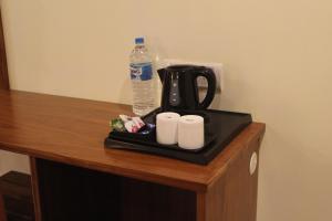 einen Tisch mit einer Kaffeemaschine und einer Flasche Wasser in der Unterkunft Vasathi in Madikeri