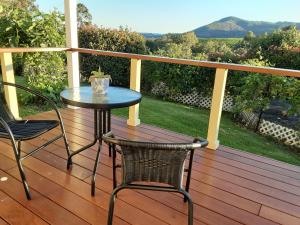 a table and two chairs on a deck with a view at Mistress Block Vineyard in Pokolbin