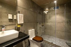 a bathroom with a sink and a toilet and a shower at Nau Nabh Cottage by VEO - Part of StayVista in Shimla +84 photos
