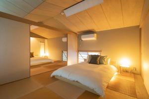 a bedroom with two beds and two lights in it at Shiki&Kura in Kurashiki