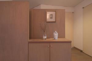 Zimmer mit einer Theke mit einer Vase und einem Bild in der Unterkunft Shiki&Kura in Kurashiki