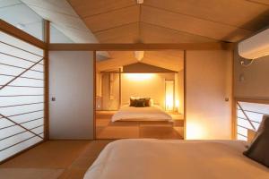 1 dormitorio con 1 cama grande en una habitación en Shiki&Kura, en Kurashiki