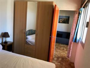 um quarto com uma porta que leva a uma cama e um espelho em Appartement Port Leucate, 2 pièces, 5 personnes - FR-1-81-49 em Port Leucate