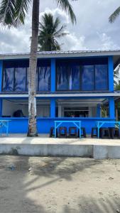 een blauw gebouw met tafels en stoelen ervoor bij Azure at Tranquility Bay Beach Resort in Kinabutan