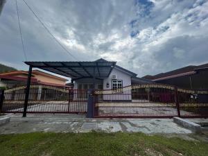 een rood hek voor een wit huis bij Homestay Salak 756 at Sungai Siput Kuala Kangsar for Islamic Guest Only in Sungei Siput