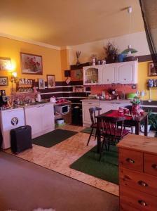 una cocina con armarios blancos y una mesa. en Pension Relax-Hvězdička, en Litoměřice