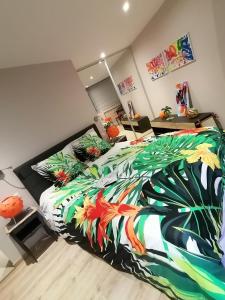 a bedroom with a bed with a colorful comforter at Le Paul Chandon Centre-ville 4 pers in Épernay