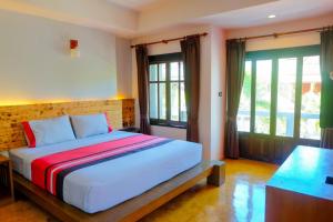 a bedroom with a large bed in a room with windows at See Through Resort Haad Yao in Haad Yao