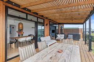 uma sala de jantar com uma mesa de madeira e cadeiras em Tapuaetahi Beach Marvel - Te Tii Holiday Home em Waipapa